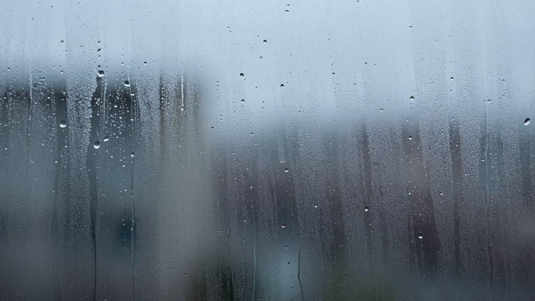 Ein Fenster von außen fotografiert, Wasser tropft und spritzt an der Scheibe herunter, subtiler Bezug zum Squirting, abstrakt und künstlerisch
